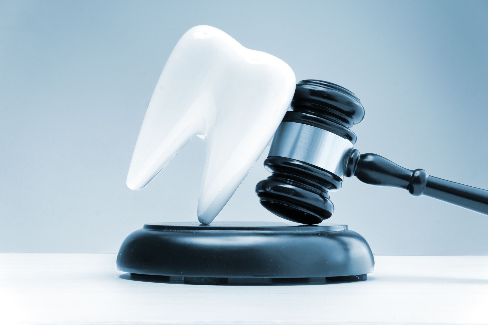 Concept Dental Law: Tooth model and gavel symbolizing legal aspects of dentistry, medical liability, and insurance