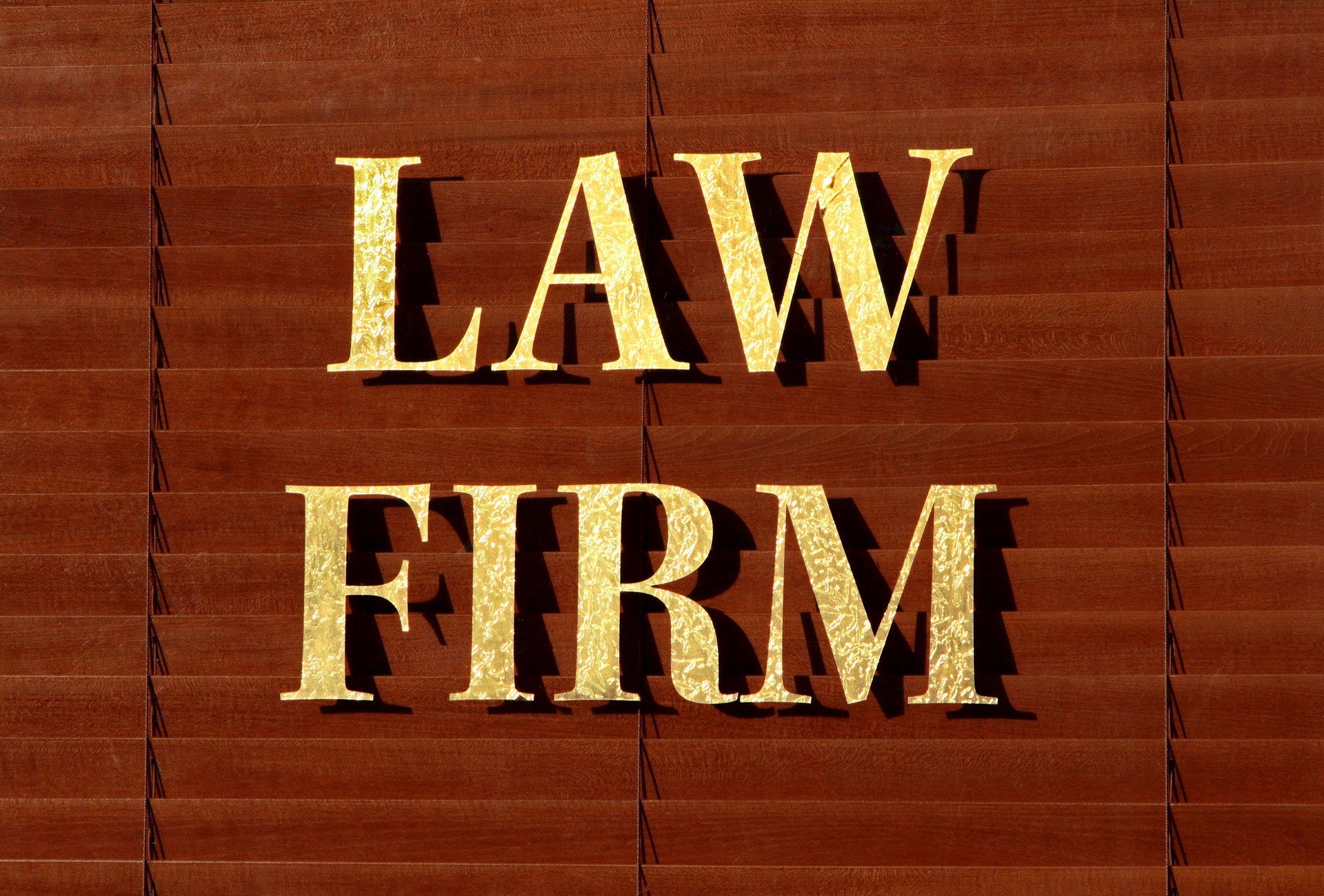 Window with brown shades and LAW FIRM in gold lettering