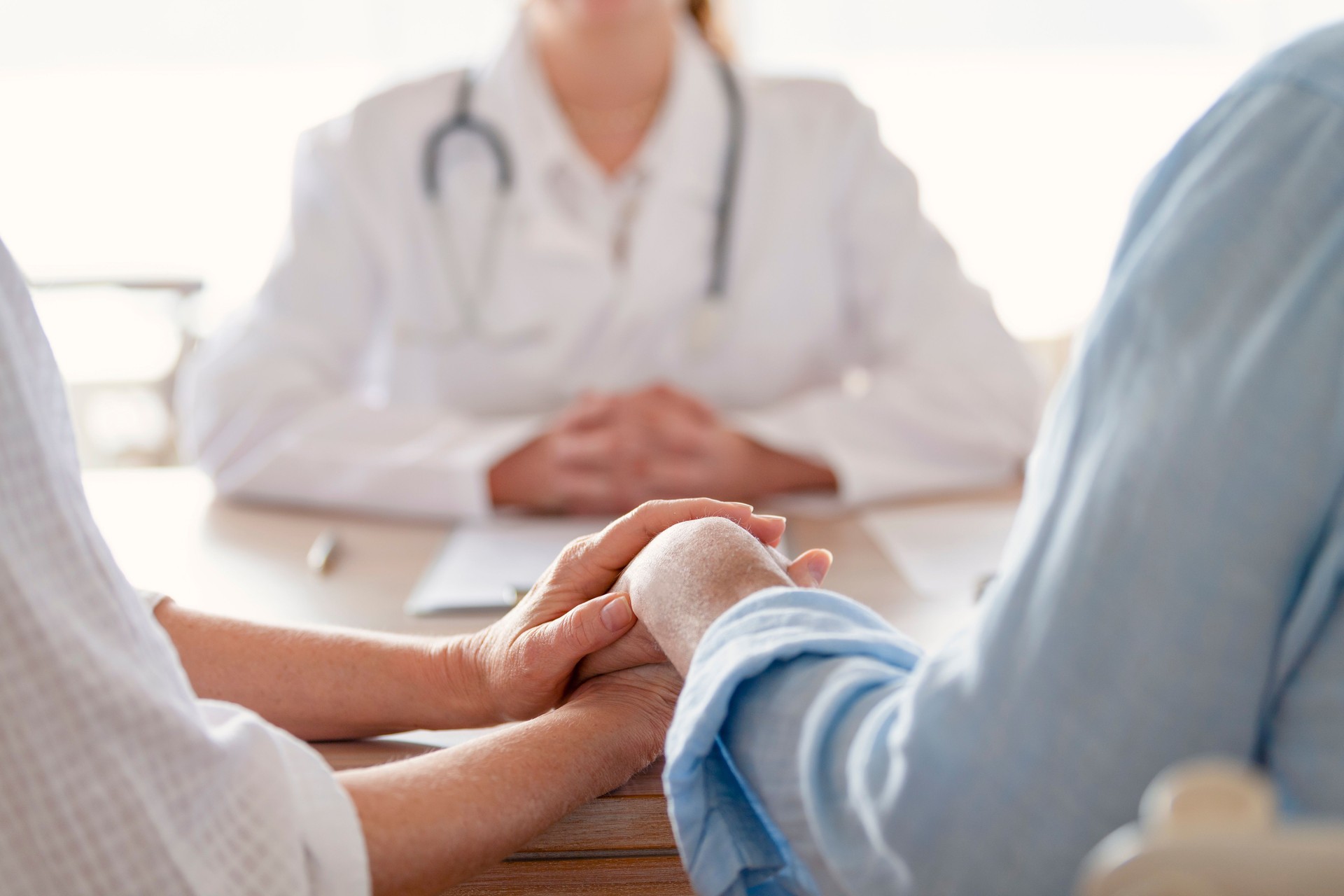 Mature couple holding hands at a doctors office.